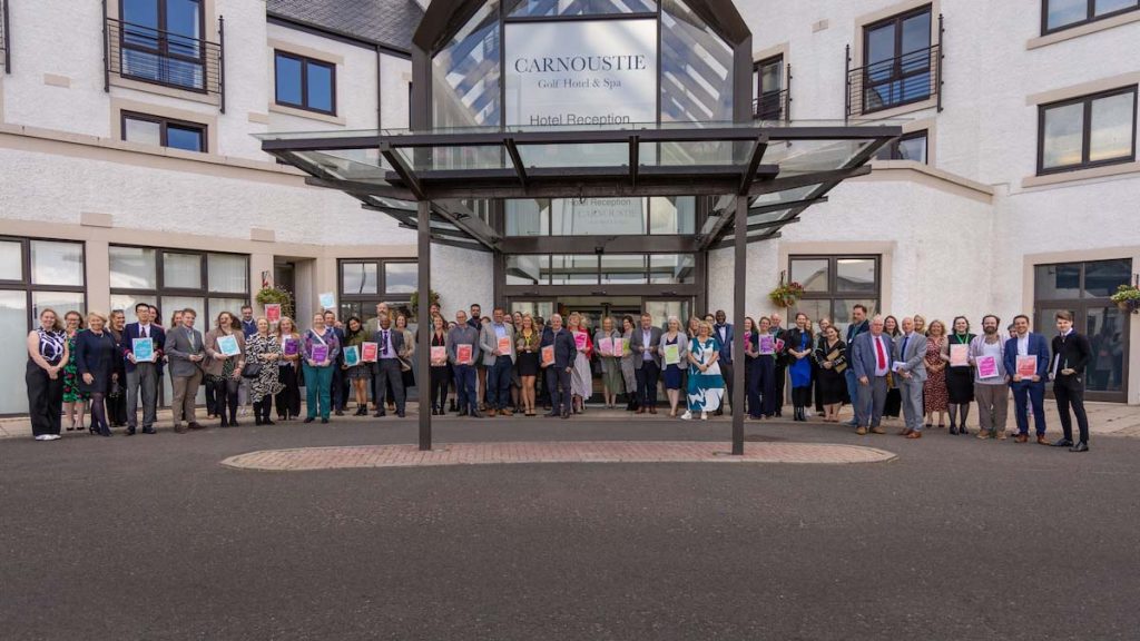 A large group of winners and finalists from the Dundee and Angus Chamber of Commerce Awards 2024 standing outside the Carnoustie Golf Hotel