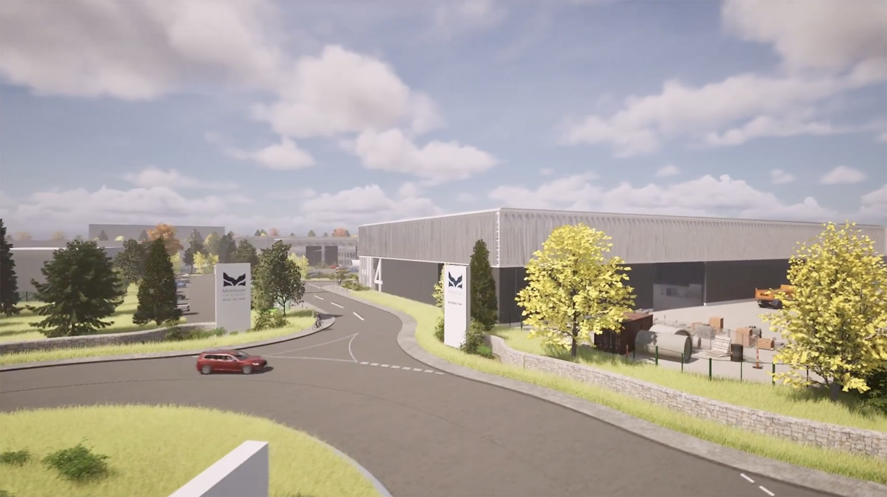 A red car drives on a curved road leading to a large industrial building complex with signs displaying a black bird logo, surrounded by grass, trees, and a partly cloudy sky.