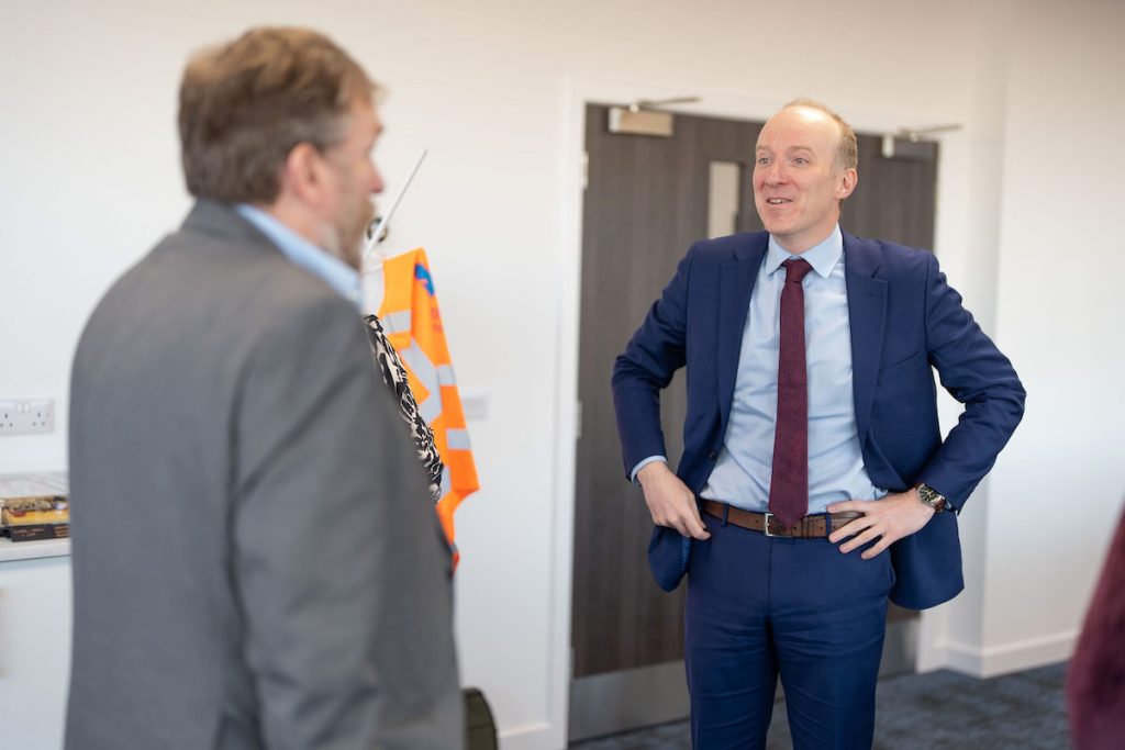 Michael Marra MSP standing with his hands on his hips and speaking to Montrose Port Authority CEO, Tom Hutchison. who has his back top the camera. 